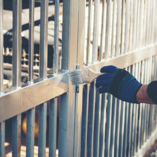 Construction worker painting fence at home, closeup